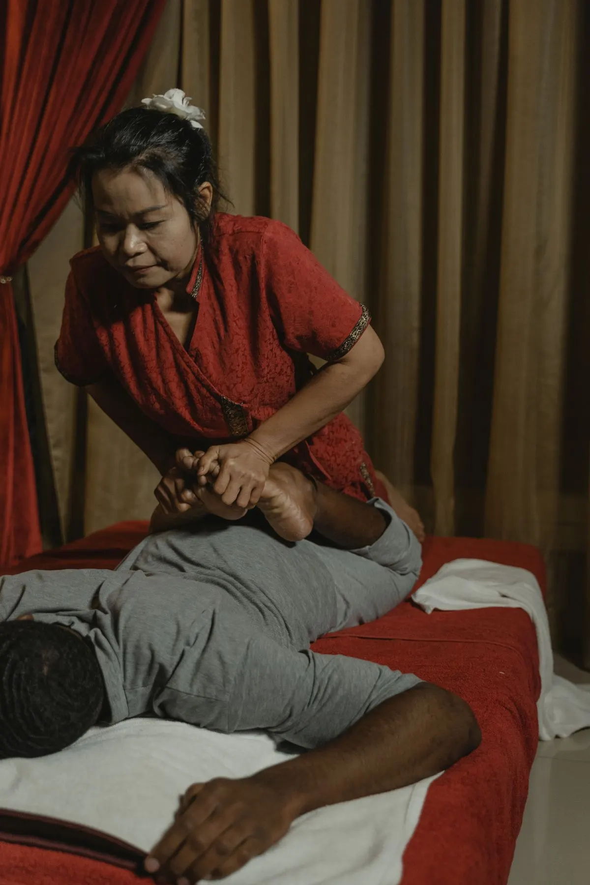 Close-up of a therapist's hands pressing on a client's foot and leg